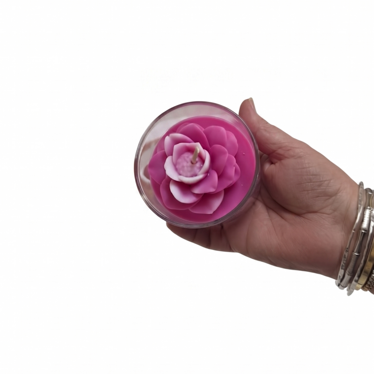 Hand holding a pink flower in a small container against a white background